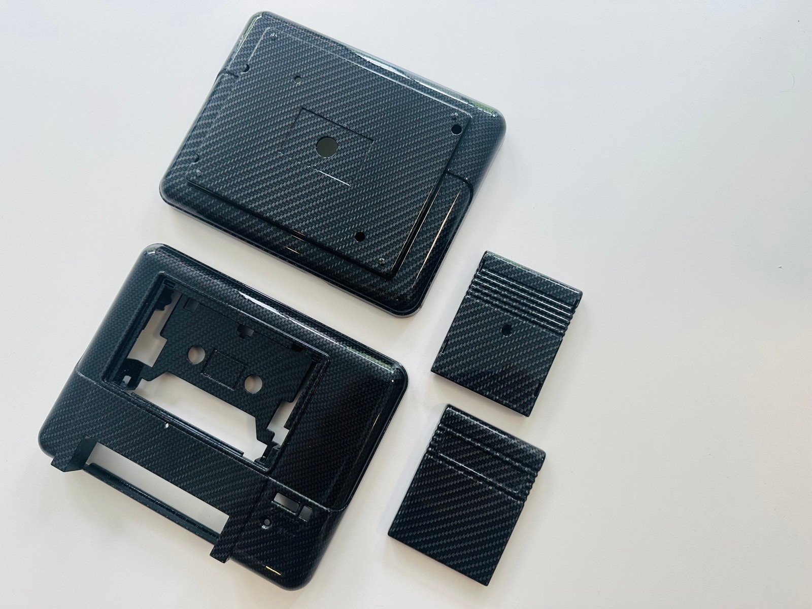 Rozłożone na części elementy obudowy Commodore 64: górna skorupa, wewnętrzny stelaż i osłony portów
